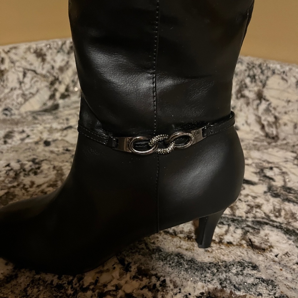 Women’s heeled black faux leather boots.